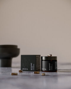 AVEA Biomind+ Nahrungsergänzung auf einer hellen Steinoberfläche mit Verpackung, geöffnetem Glas und verstreuten Kapseln.